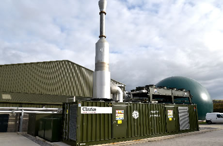 A photograph of GE's contrainerised Jenbacher gas engines at Biogen's St Asaph anaerobic digestion facility along with waste reception area and biogas storage baloon